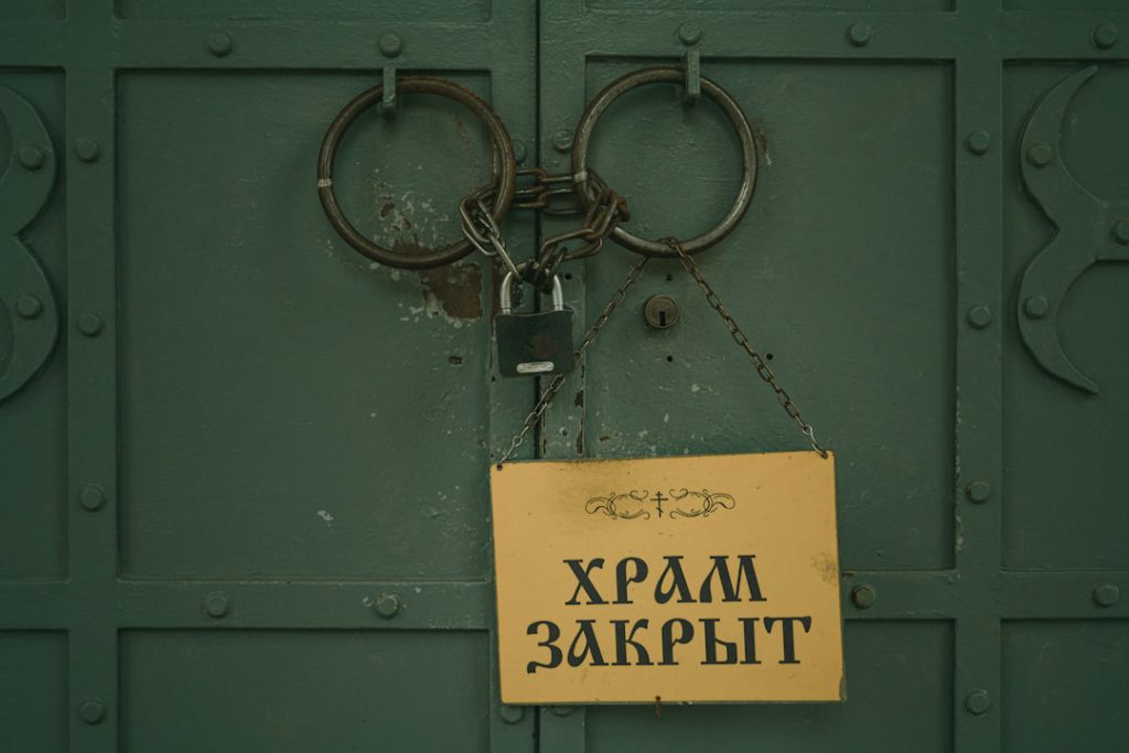 A yellow sign hanging on a green door